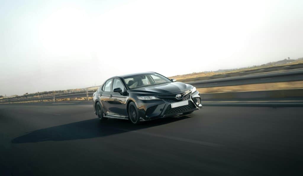 A sleek Toyota Camry in motion on a highway, capturing the essence of speed and style.