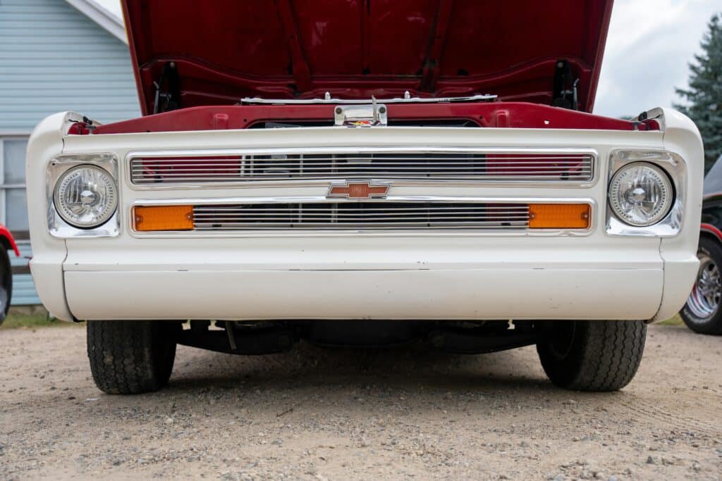 Close-up of a vintage Chevrolet pickup's front, displaying its distinctive grill and open hood.