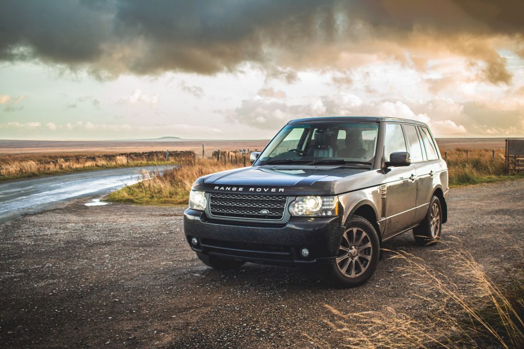 A stylish Range Rover parked on a rural road with dramatic skies.