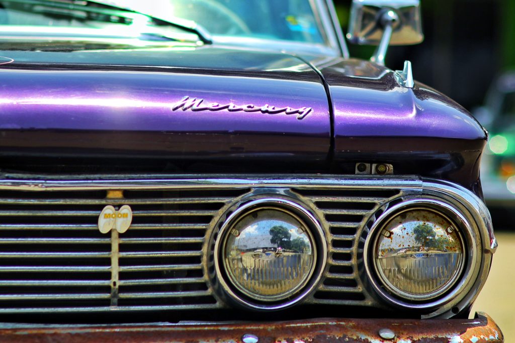 Close-up of a vintage Mercury car grille with reflections, captured in Bandung, Indonesia.